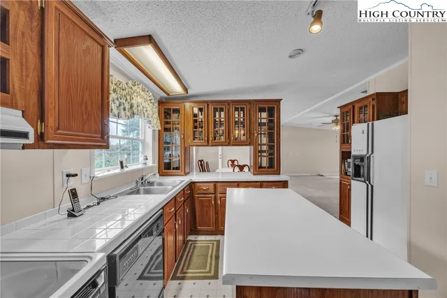 a kitchen with stainless steel appliances granite countertop a sink and a refrigerator