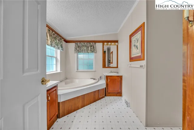 a bathroom with a tub sink and mirror