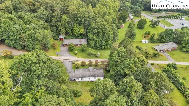 an aerial view of residential house with outdoor space and trees all around