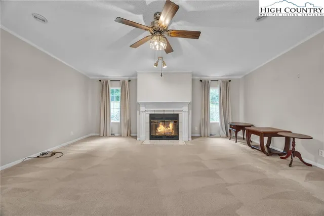 a view of an empty room with chandelier fan and a fireplace