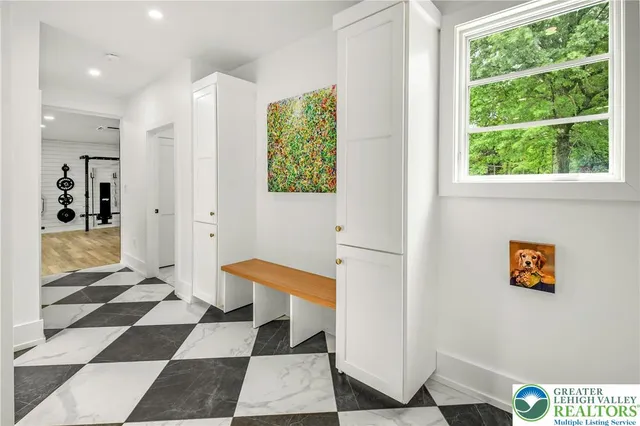 a hallway with a black white checkered floor and a large window