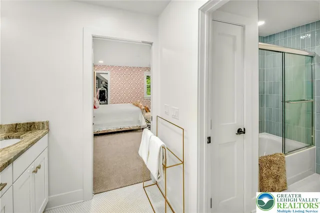 a en suite bathroom with a granite countertop sink and a mirror