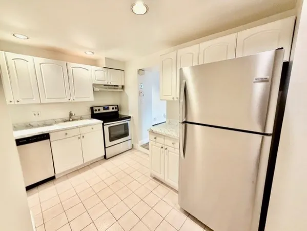 a kitchen with white cabinets and white stainless steel appliances