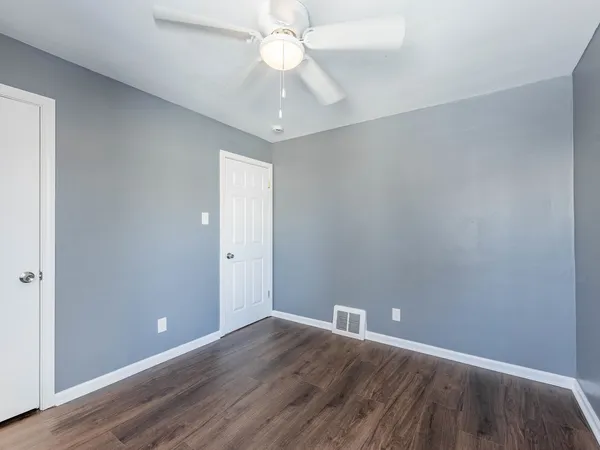 a view of an empty room with wooden floor