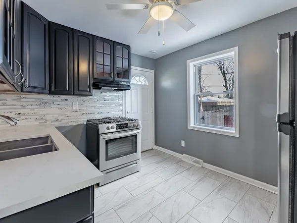a kitchen with stainless steel appliances granite countertop a stove a sink and a refrigerator