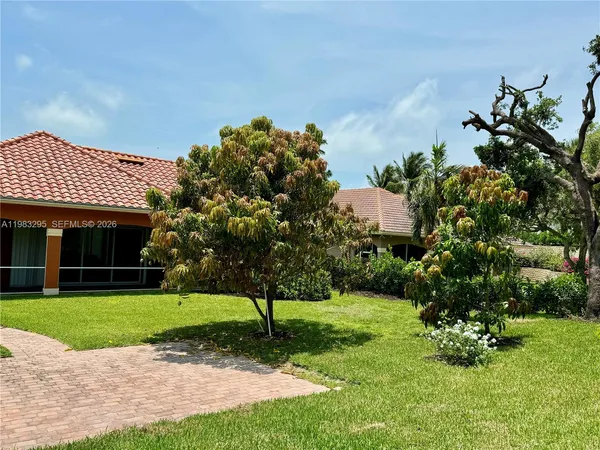 a front view of a house with a yard and green space