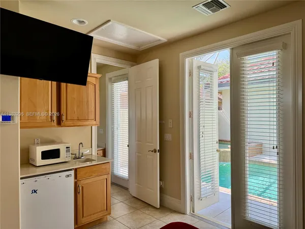 a view of a dining room and livingroom with furniture wooden floor a chandelier