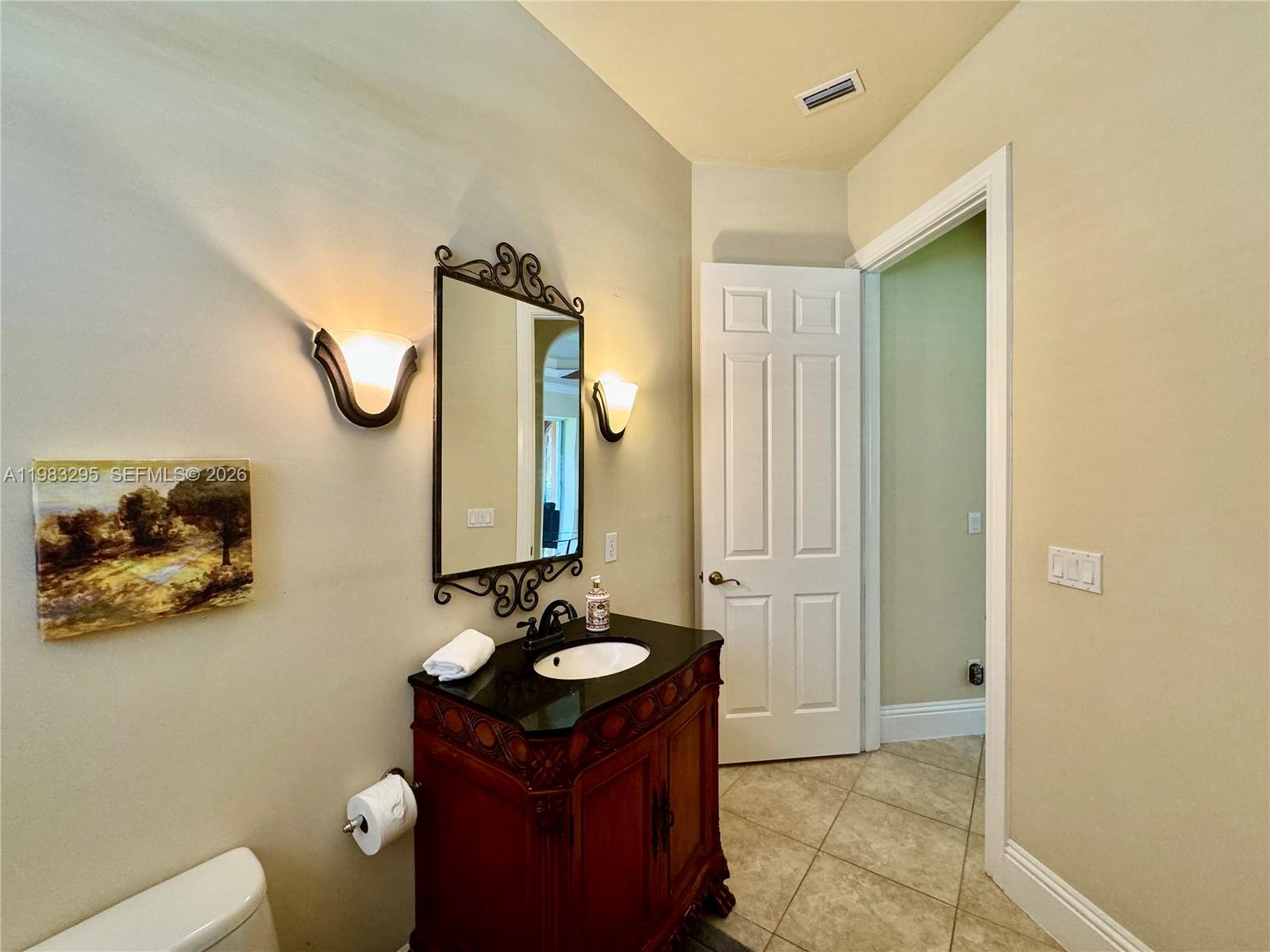 1740 Ludlow Road, Unit 1740 Marco Island, FL 34145 - Photo 43 of 58 a bathroom with a sink and mirror with toilet