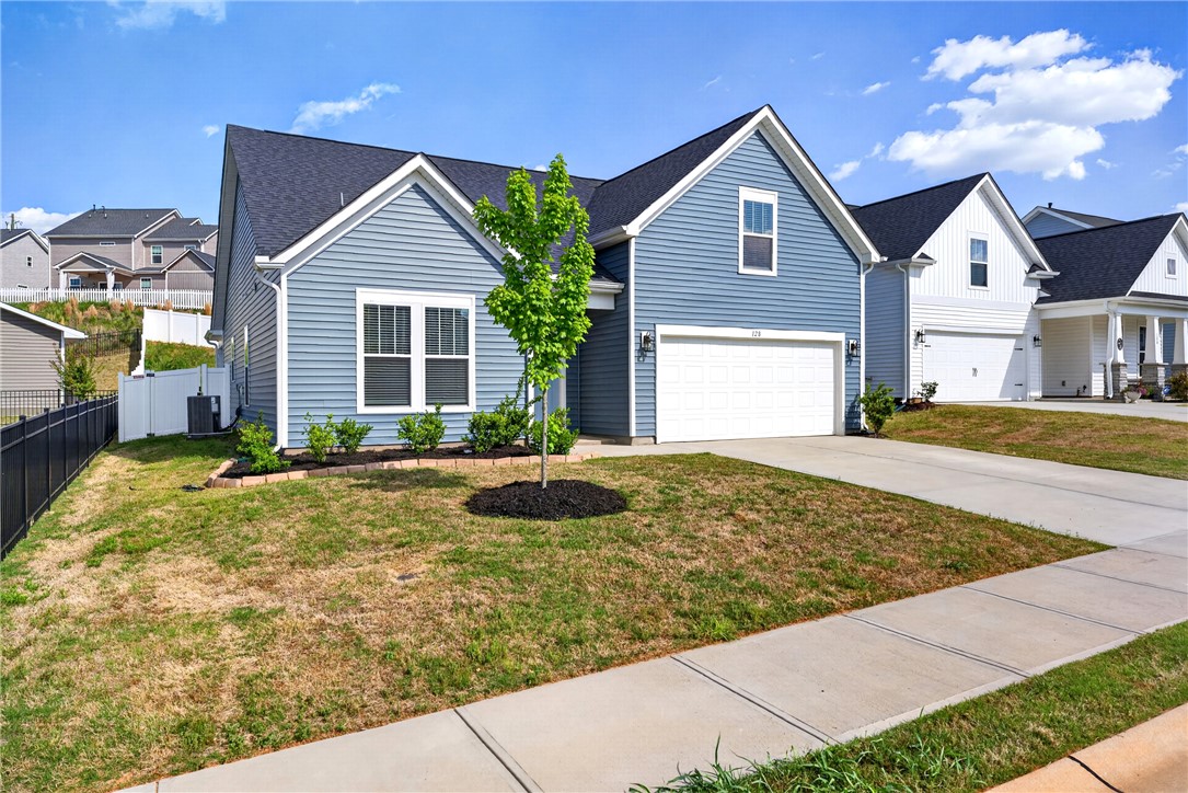 128 Whitman Way Easley, SC 29642 - Photo 34 of 34 This charming home showcases a well-maintained exterior, featuring a driveway, attached garage, and neatly landscaped yard.