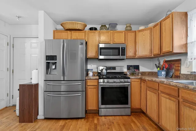 a kitchen with stainless steel appliances granite countertop a stove a refrigerator and a microwave