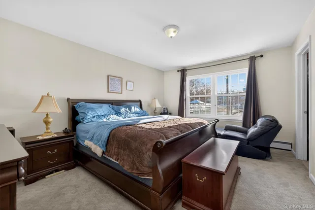 a bedroom with a bed and a lamp on dresser