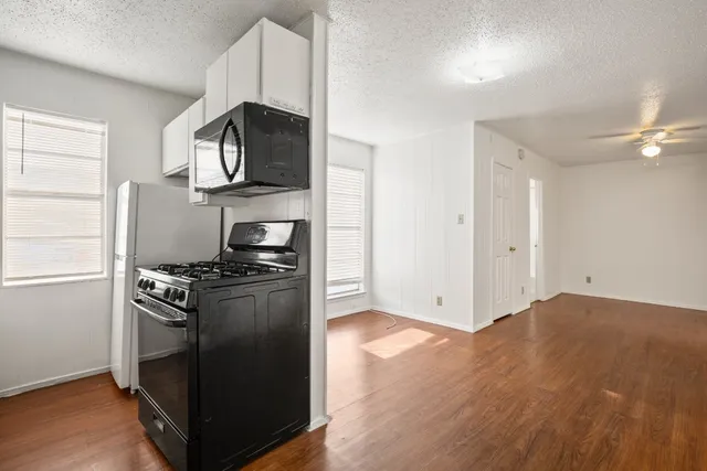 a kitchen with granite countertop a stove and a refrigerator