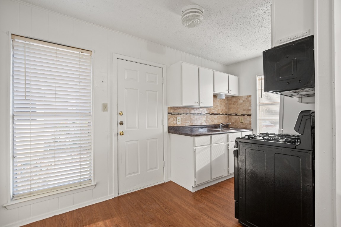 5300 Guadalupe Street, Unit 108 Austin, TX 78751 - Photo 4 of 11 a kitchen with stainless steel appliances granite countertop a stove a sink and a microwave