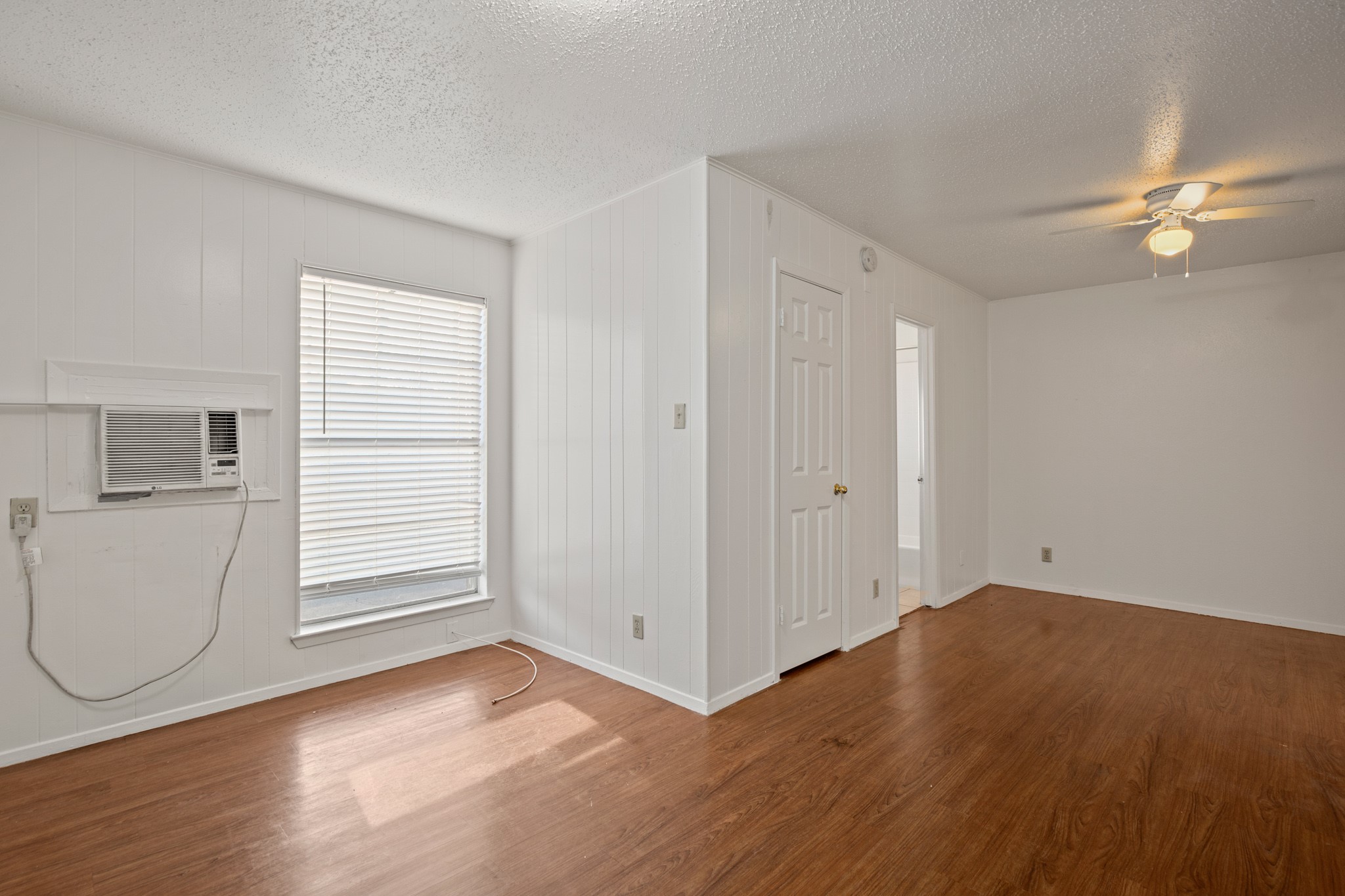 5300 Guadalupe Street, Unit 108 Austin, TX 78751 - Photo 5 of 11 an empty room with wooden floor cabinet and windows