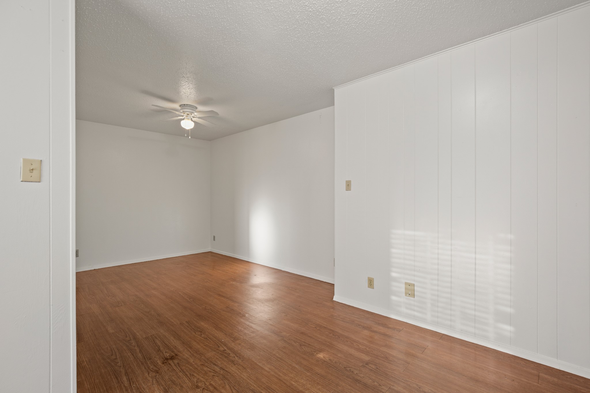 5300 Guadalupe Street, Unit 108 Austin, TX 78751 - Photo 6 of 11 an empty room with wooden floor and fan