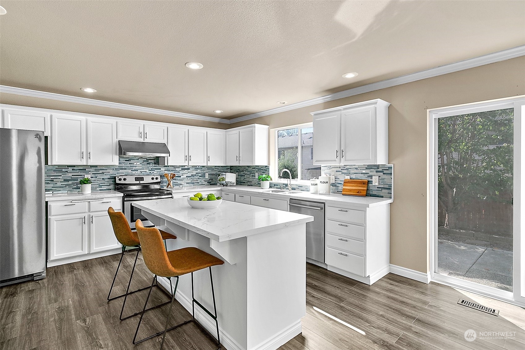 6723 Southeast 4th Street Renton, WA 98059 - Photo 12 of 38 a kitchen with stainless steel appliances kitchen island granite countertop a refrigerator a stove top oven a sink and white cabinets with wooden floor