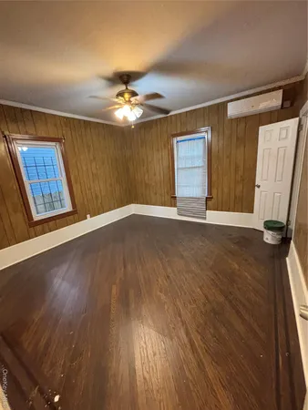 a view of an empty room with a window and wooden floor