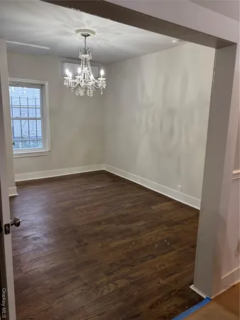 a view of a room with wooden floor and chandelier