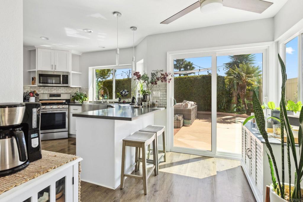 1896 Timber Trail Vista, CA 92081 - Photo 34 of 65 a kitchen with stainless steel appliances kitchen island granite countertop a refrigerator a stove top oven a sink with a dining table and chairs