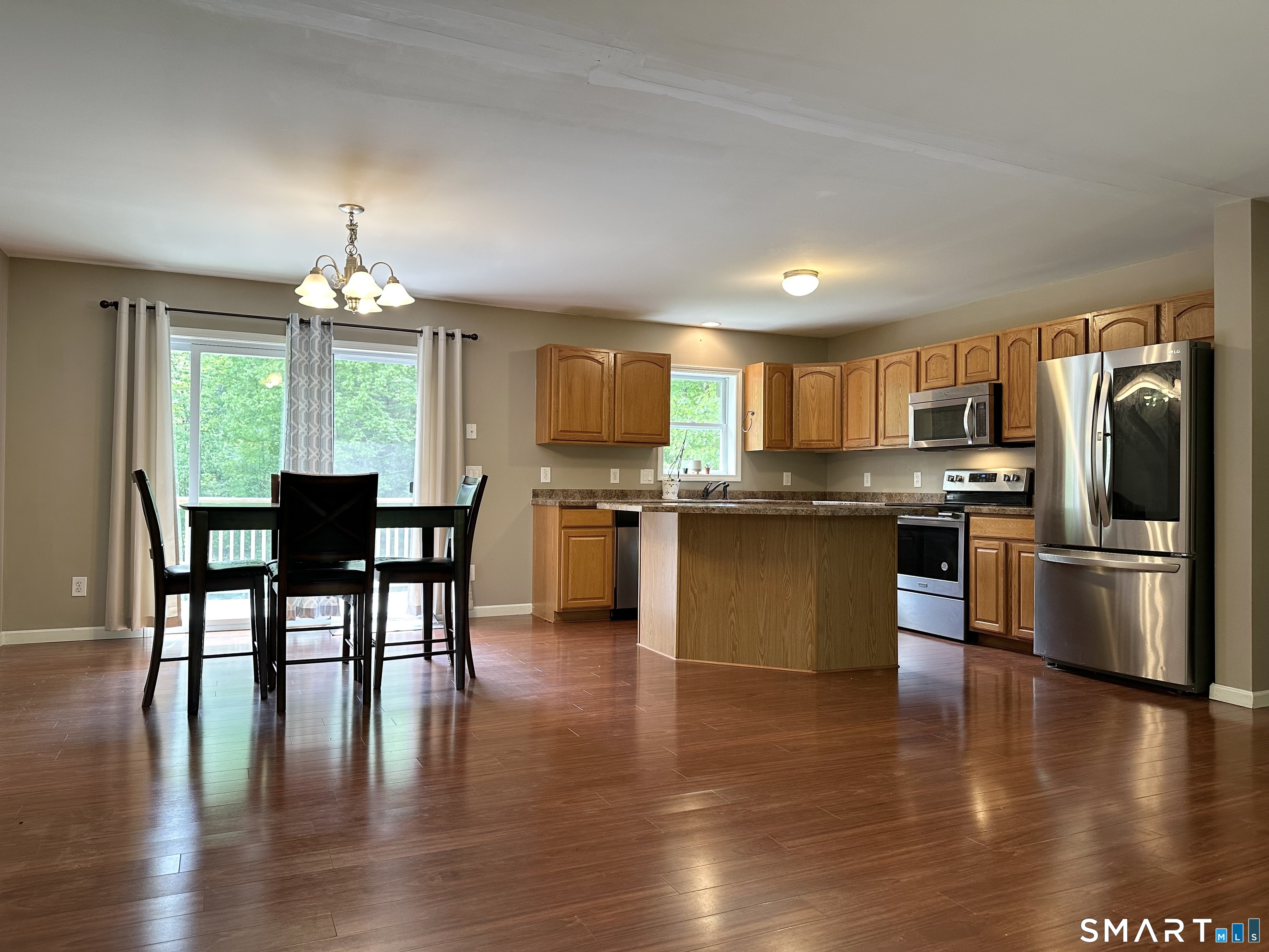 116 Tatnic Hill Road Brooklyn, CT 06234 - Photo 14 of 27 a kitchen with stainless steel appliances granite countertop a stove top oven a sink dishwasher a dining table and chairs with wooden floor
