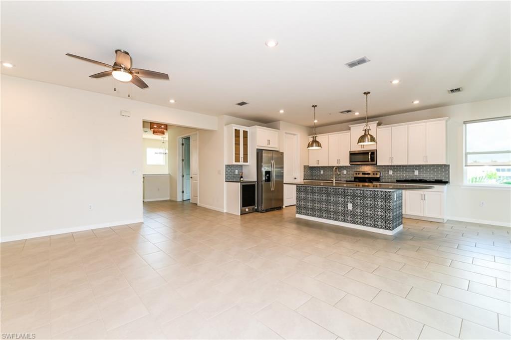 4721 Arboretum Circle, Unit 201 Naples, FL 34112 - Photo 24 of 26 a kitchen with stainless steel appliances kitchen island granite countertop a refrigerator and a stove top oven