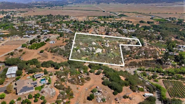 an aerial view of residential houses with outdoor space and trees