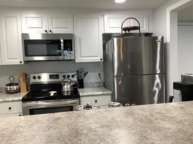 a kitchen with stainless steel appliances a refrigerator stove and microwave