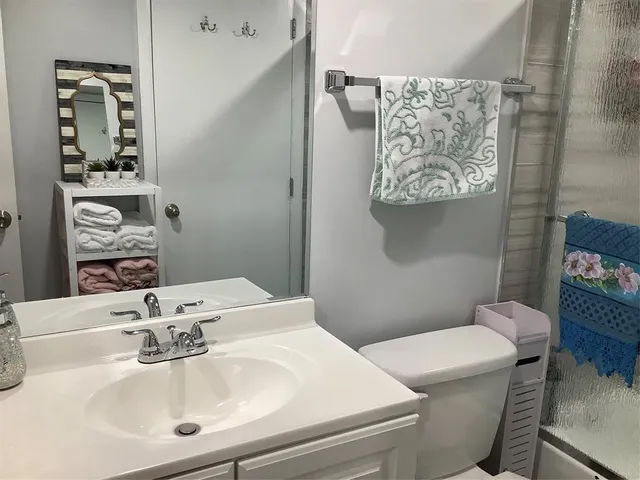 a bathroom with a sink mirror and toilet