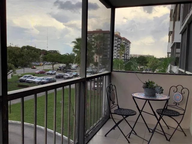 a view of a balcony with table and chairs and wooden fence