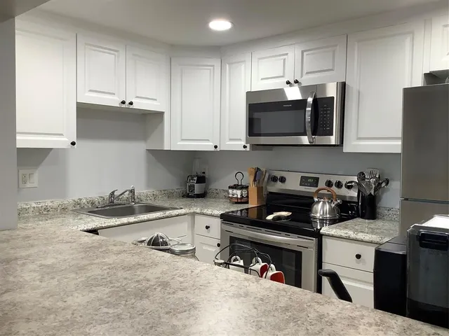 a kitchen with stainless steel appliances granite countertop a stove and a refrigerator