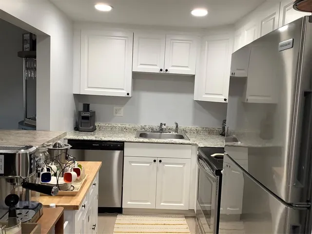 a kitchen with stainless steel appliances granite countertop a refrigerator and a stove top oven