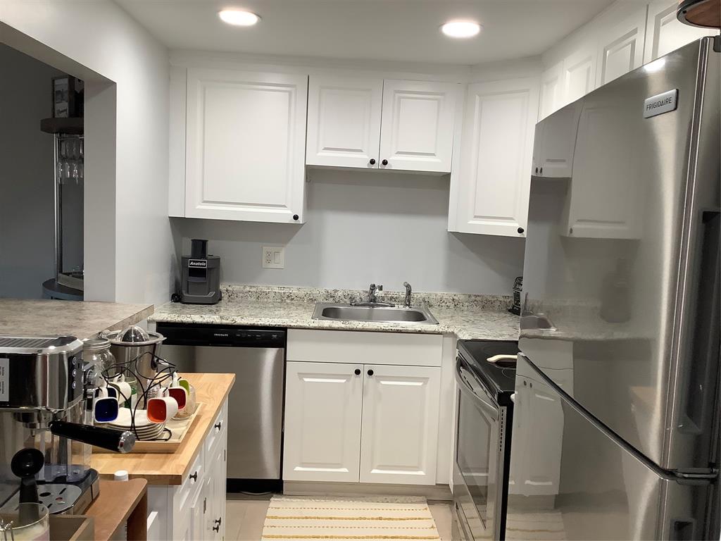 4174 Inverrary Drive, Unit 309 Lauderhill, FL 33319 - Photo 5 of 21 a kitchen with stainless steel appliances granite countertop a refrigerator and a stove top oven