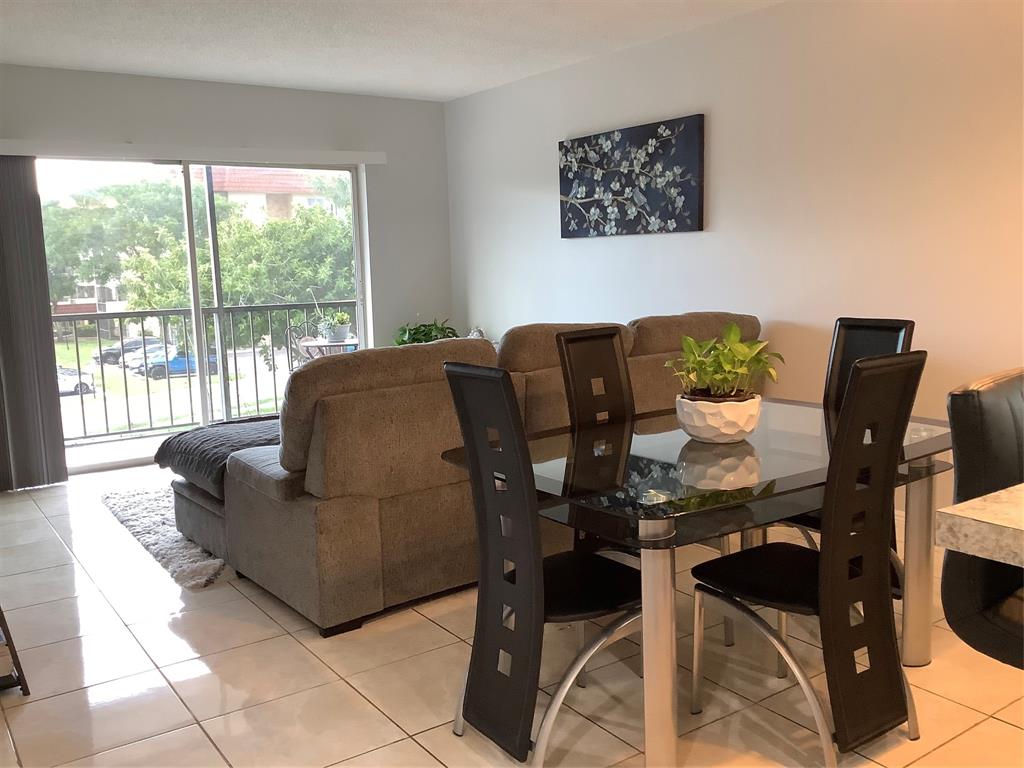 4174 Inverrary Drive, Unit 309 Lauderhill, FL 33319 - Photo 8 of 21 a living room with furniture and a floor to ceiling window