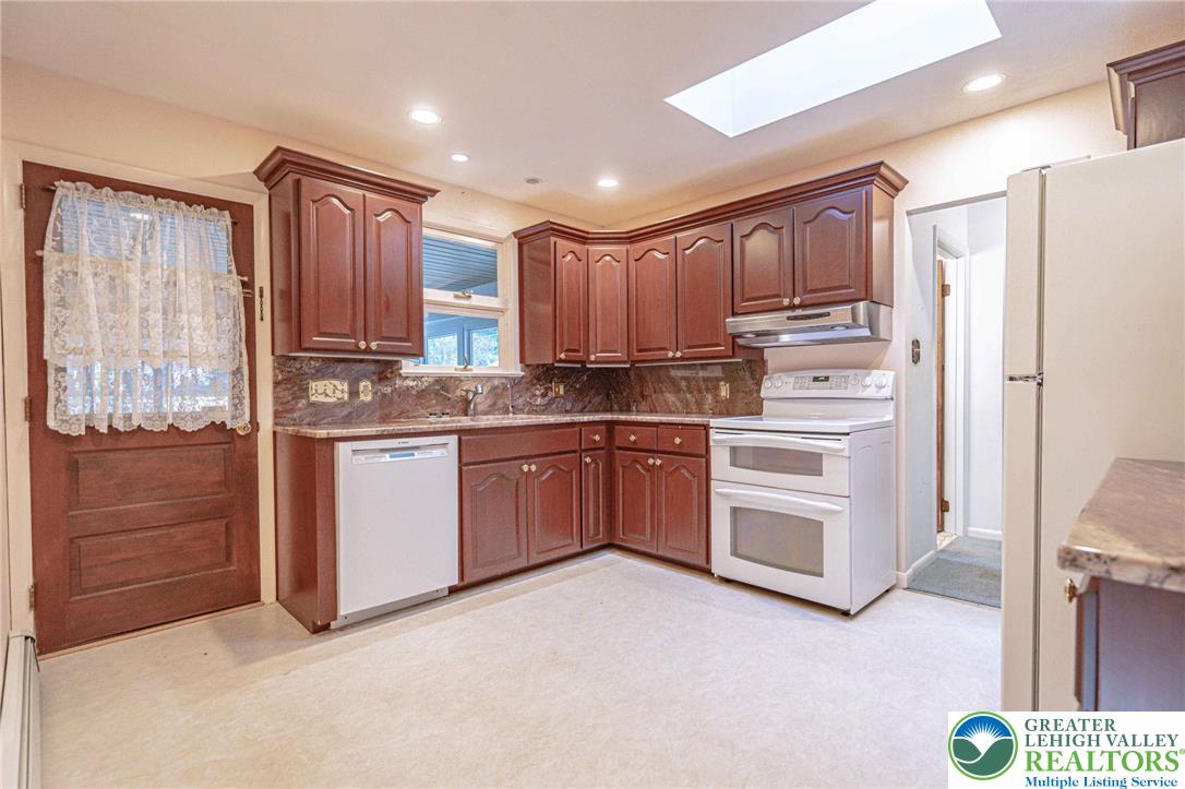 258 Kohlers Hill Road Kutztown, PA 19530 - Photo 18 of 60 a kitchen with kitchen island granite countertop wooden cabinets and white appliances