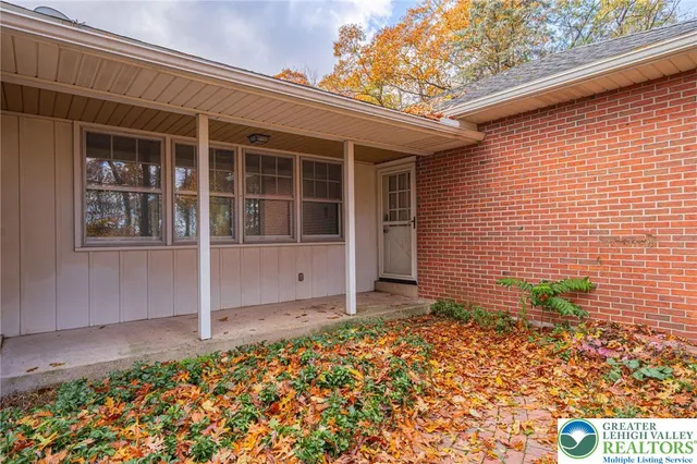 a view of an empty room with wooden floor fireplace and a window