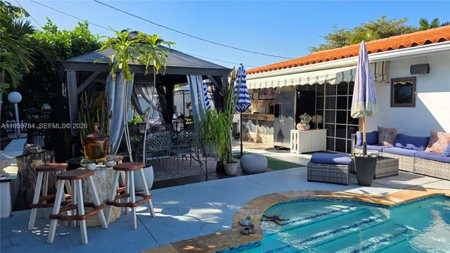 a view of a patio with table and chairs potted plants and a large tree
