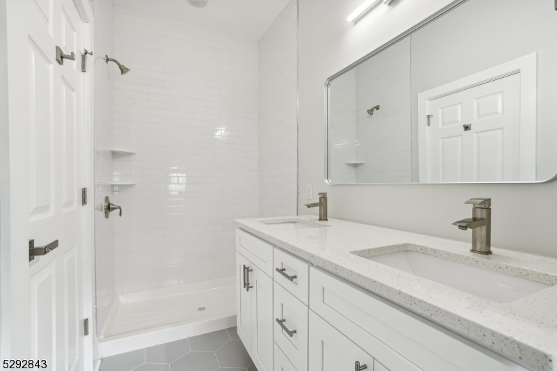 29 Arlington Road, Unit 1 Cranford, NJ 07016 - Photo 13 of 15 a bathroom with a sink double vanity granite tub shower and a mirror