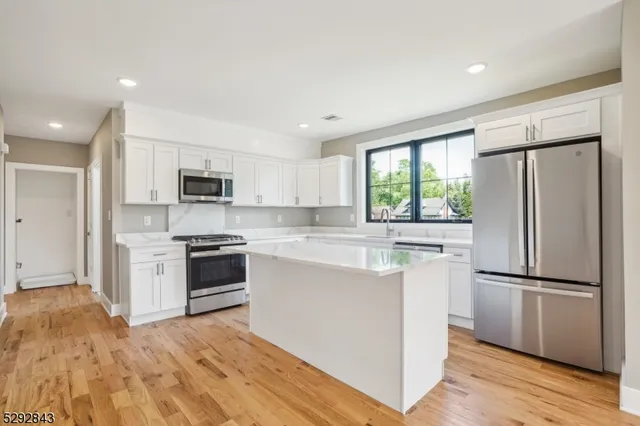 a kitchen with stainless steel appliances a refrigerator sink and microwave