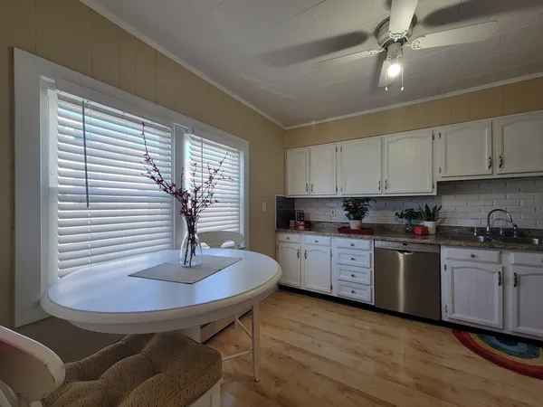 a kitchen with stainless steel appliances granite countertop a sink dishwasher and a stove with wooden floor