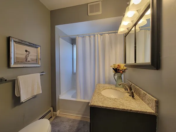 a bathroom with a granite countertop sink and a mirror