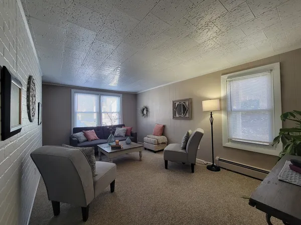a living room with furniture a window and a flat screen tv