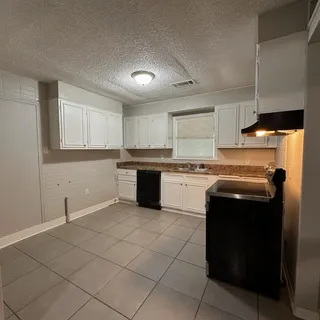 a kitchen with a sink a stove and cabinets