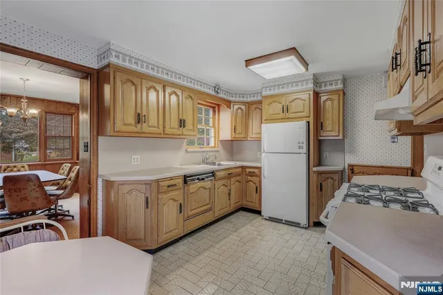 a kitchen with a refrigerator and a stove top oven