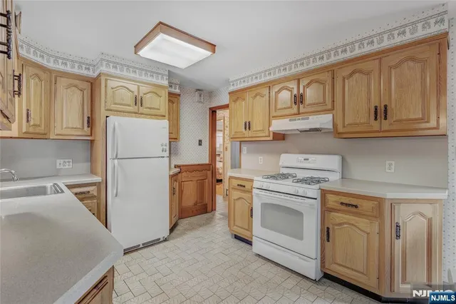 a kitchen with a stove top oven a refrigerator and cabinets