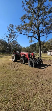 a backyard of a house with table and chairs under an umbrella