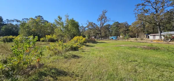 a backyard of a house with table and chairs under an umbrella