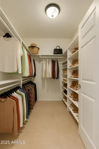a view of walk in closet with clothes and shoes