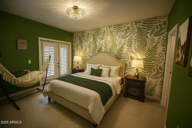 a bedroom with a bed chair and wall painting