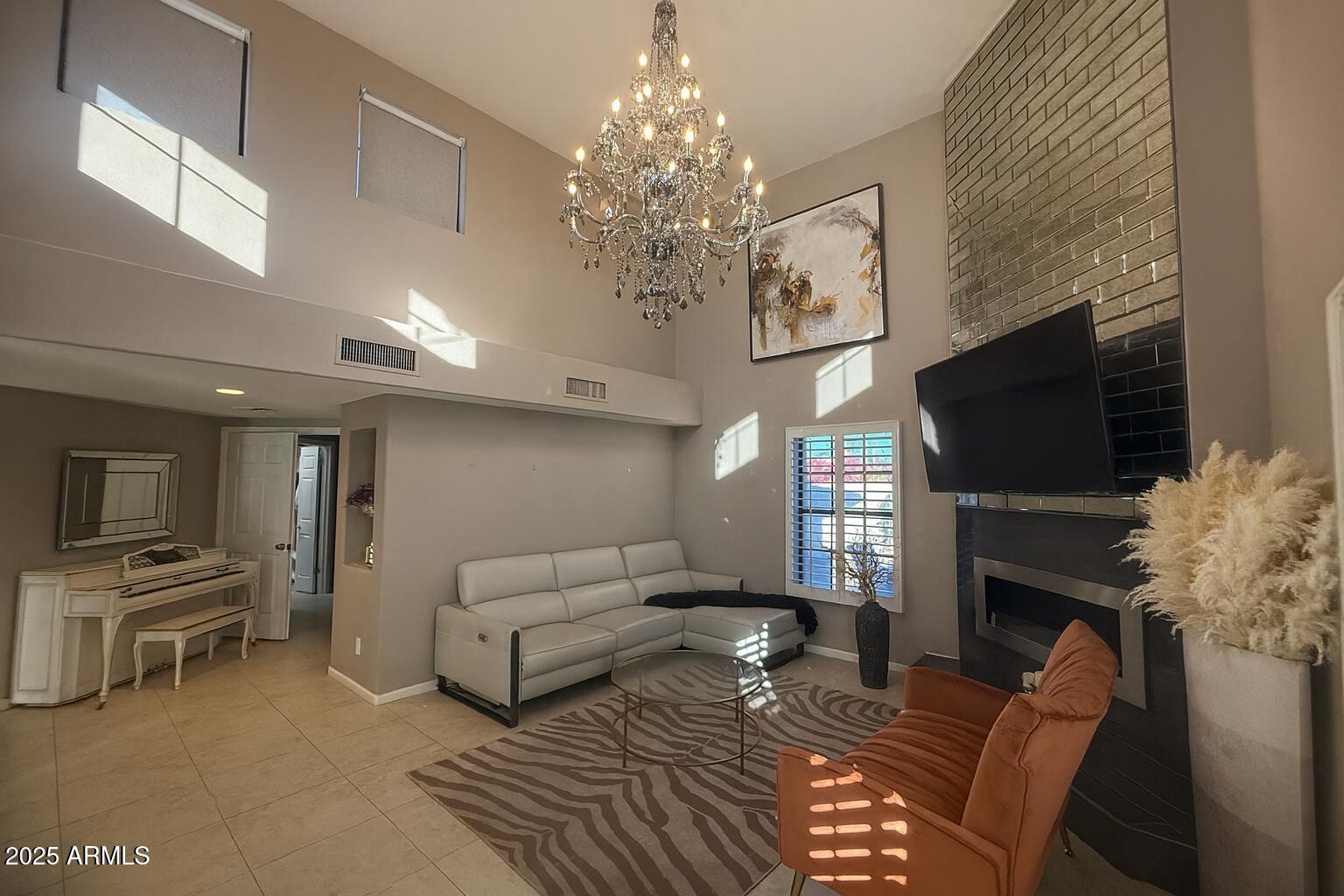 8100 East Camelback Road, Unit 163 Scottsdale, AZ 85251 - Photo 6 of 51 a living room with furniture a flat screen tv and a fireplace