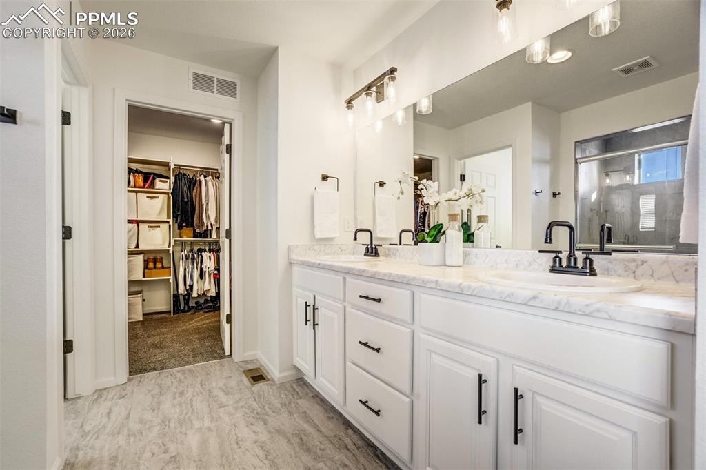 6374 Moate Lane Colorado Springs, CO 80927 - Photo 17 of 42 a spacious bathroom with a double vanity sink and mirror